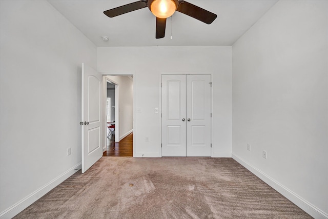 unfurnished bedroom with ceiling fan, a closet, carpet flooring, and baseboards