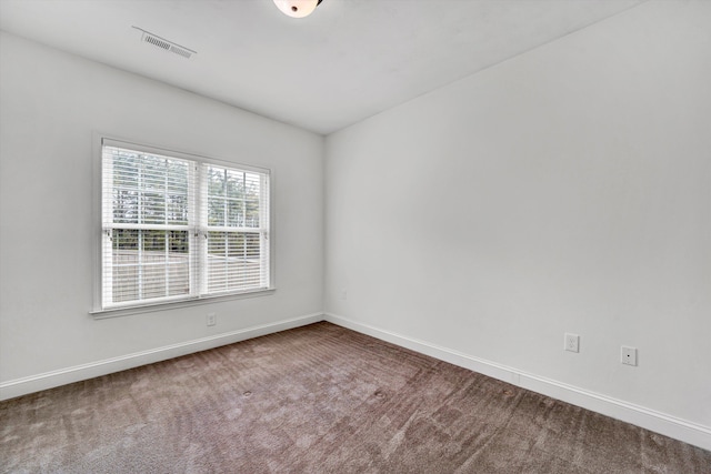 carpeted empty room with visible vents and baseboards