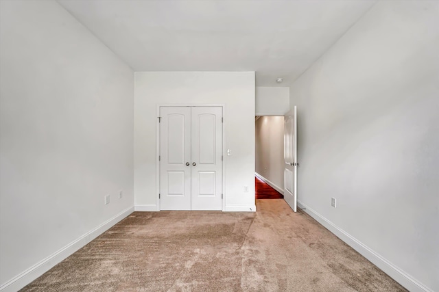 unfurnished bedroom with carpet, baseboards, and a closet