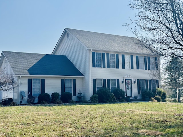 colonial inspired home featuring a front yard and an attached garage