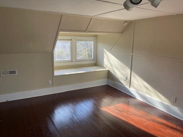 bonus room featuring visible vents, baseboards, vaulted ceiling, and wood finished floors