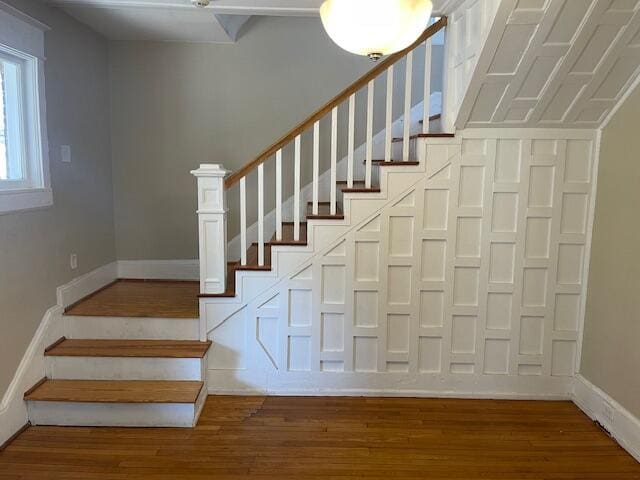 staircase with baseboards and wood finished floors