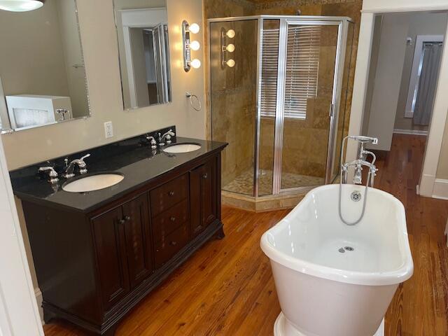 bathroom featuring a freestanding tub, a stall shower, and a sink