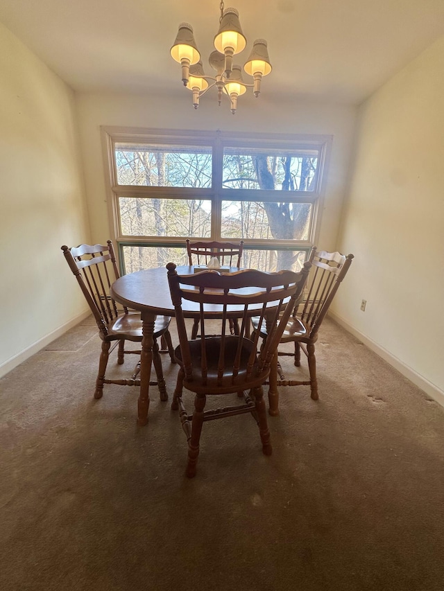 carpeted dining space with a chandelier and baseboards