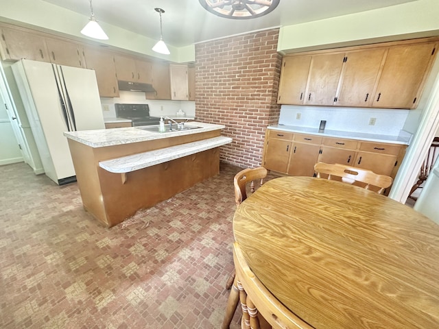 kitchen featuring electric range, brick wall, light countertops, under cabinet range hood, and a sink