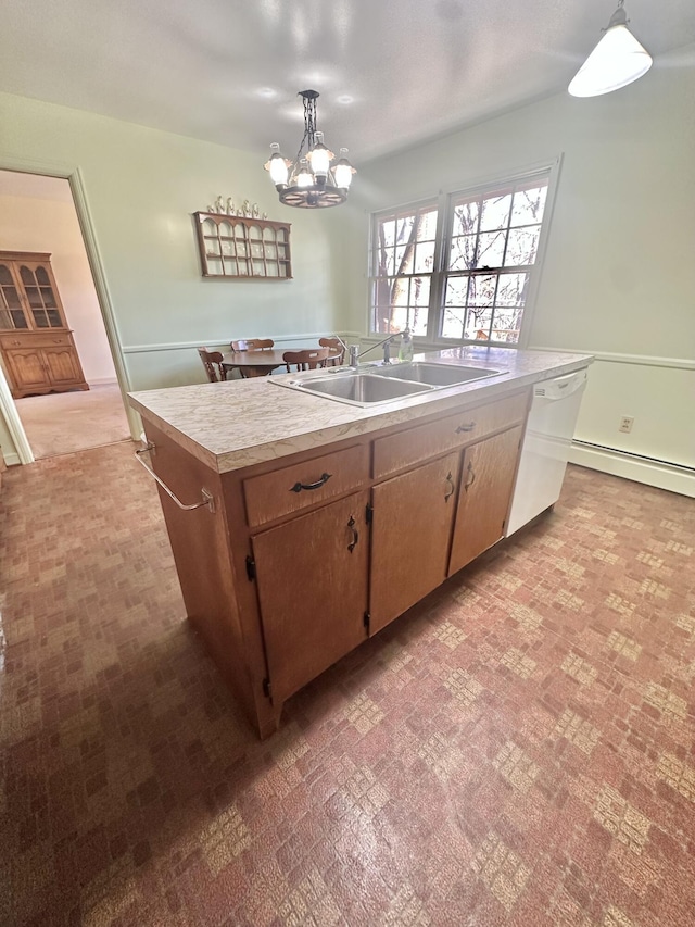 kitchen featuring a sink, light countertops, hanging light fixtures, baseboard heating, and dishwasher