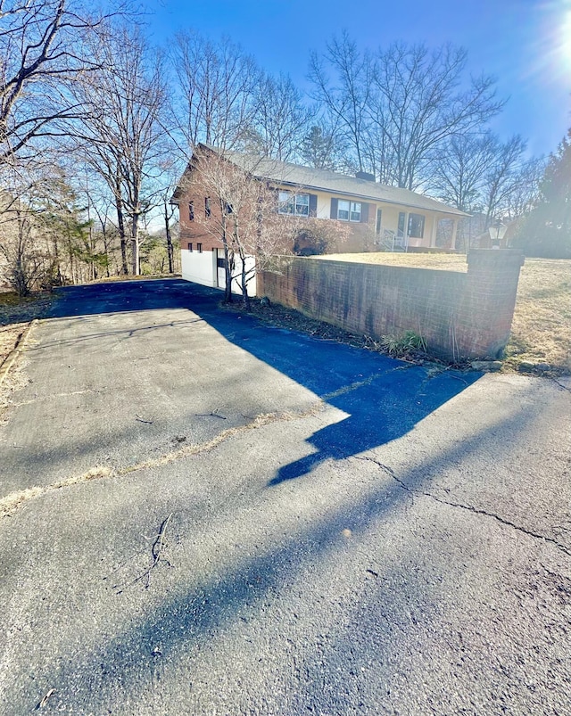 view of side of home featuring aphalt driveway