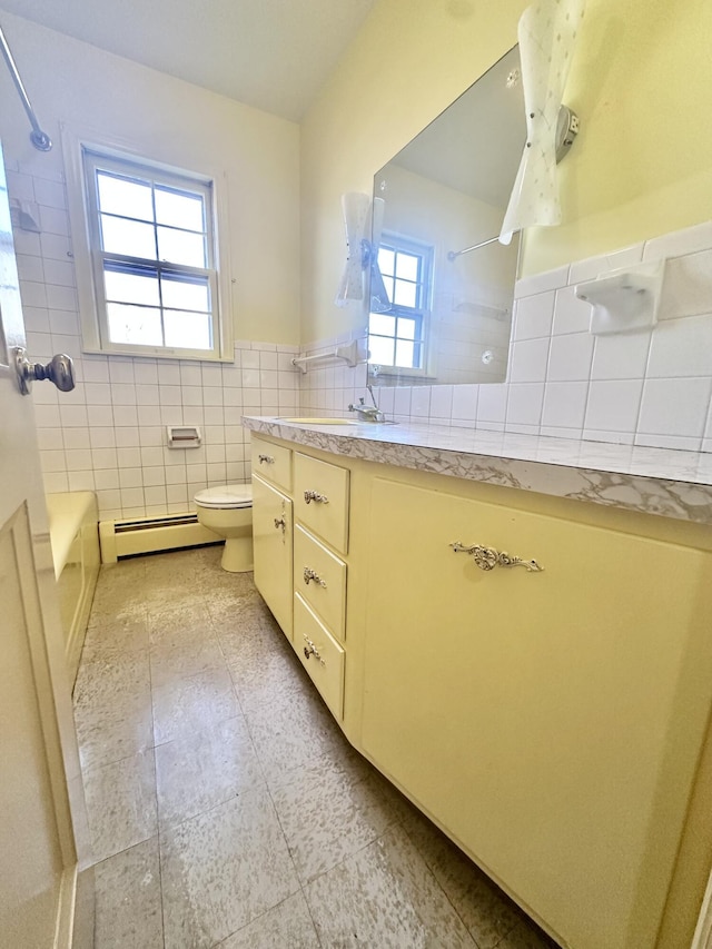 bathroom featuring bathing tub / shower combination, tile walls, a baseboard radiator, toilet, and vanity