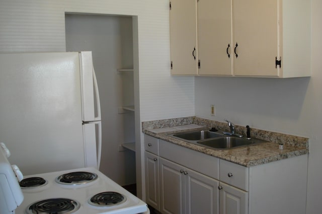 kitchen with white cabinets, white appliances, light countertops, and a sink