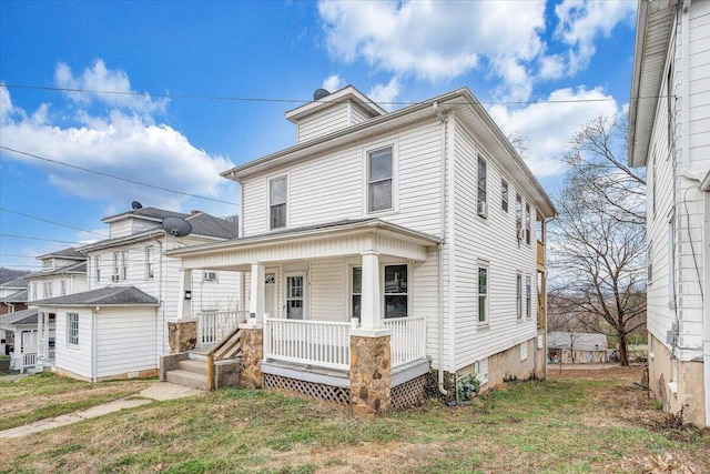 american foursquare style home with a porch and a front lawn