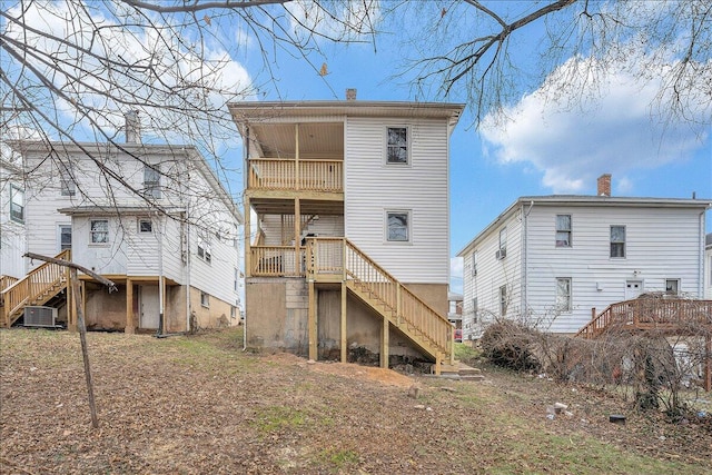 rear view of house with central AC unit, a balcony, and stairs