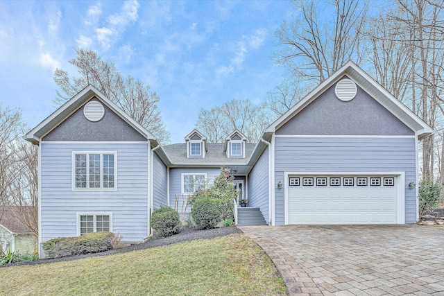 view of front of home featuring a front yard, decorative driveway, a garage, and a shingled roof