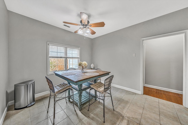 dining area featuring tile patterned floors, visible vents, baseboards, and ceiling fan