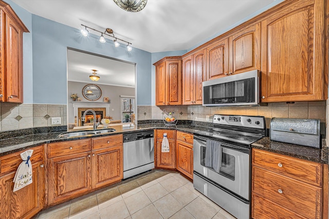 kitchen featuring a sink, stainless steel appliances, brown cabinets, and light tile patterned floors