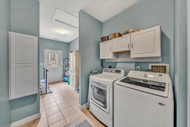 clothes washing area featuring baseboards, washing machine and dryer, attic access, light tile patterned flooring, and cabinet space