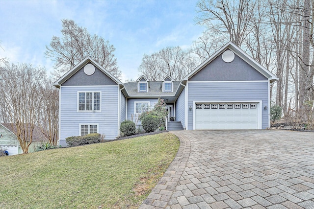 view of front of house with a front yard, decorative driveway, an attached garage, and a shingled roof