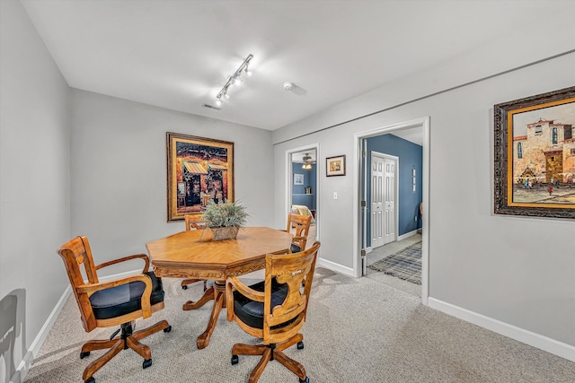 dining room featuring baseboards, carpet floors, and track lighting