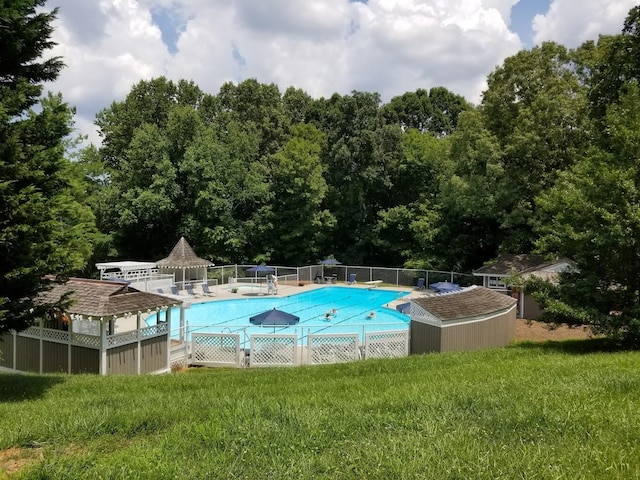 community pool featuring a yard and fence