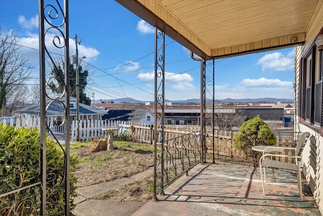 view of patio / terrace featuring fence and a mountain view