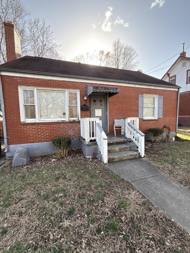 623 Arbutus Ave SE, Roanoke, VA 24014 - view of front of house with brick siding, a chimney, and a front yard
