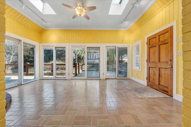 unfurnished sunroom with a skylight, a ceiling fan, and rail lighting