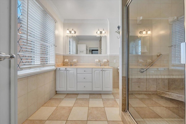 full bathroom with a stall shower, tile walls, a sink, and ornamental molding