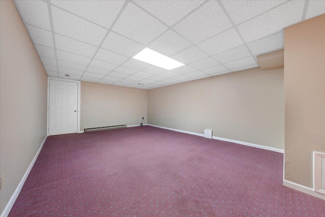 spare room with carpet floors, baseboards, baseboard heating, and a drop ceiling