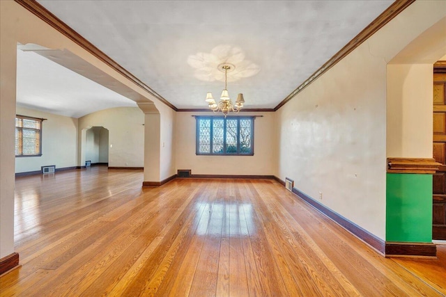 unfurnished room featuring a wealth of natural light, light wood-style flooring, visible vents, and an inviting chandelier