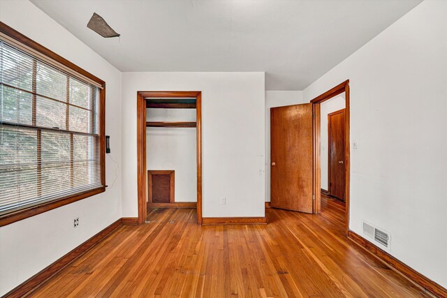 unfurnished bedroom with visible vents, baseboards, a closet, and light wood finished floors