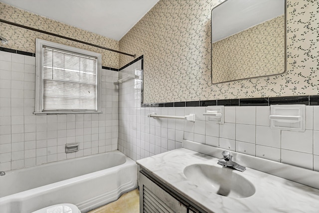 full bath featuring wallpapered walls, tile walls, shower / tub combination, and a wainscoted wall