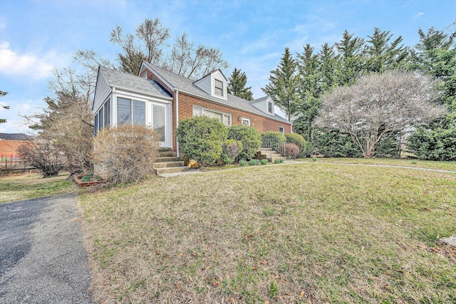 view of front of house with brick siding and a front lawn