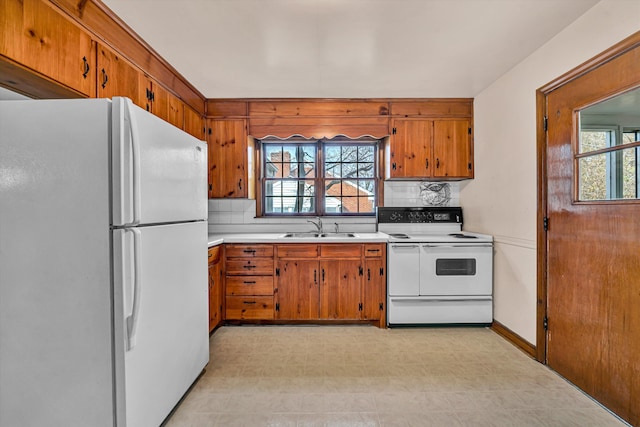 kitchen with a wealth of natural light, white appliances, light countertops, and a sink