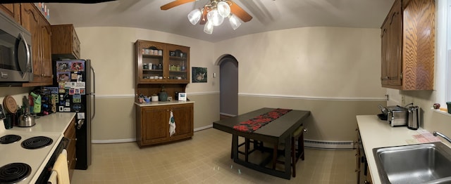 kitchen featuring brown cabinetry, light countertops, stainless steel microwave, and a sink