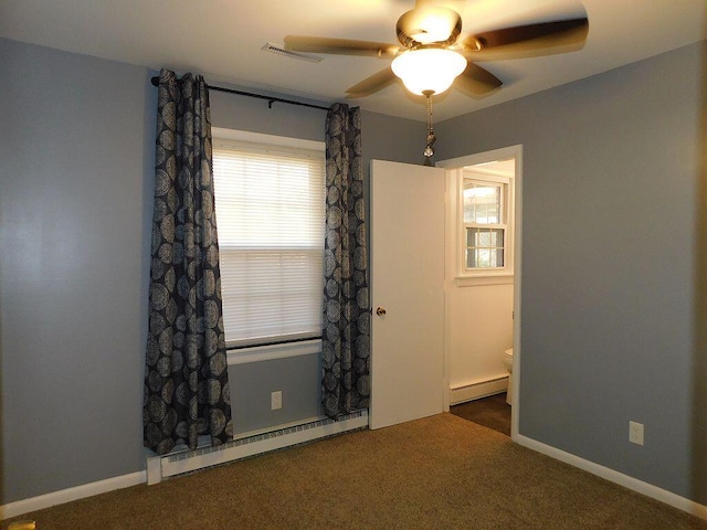 spare room featuring a baseboard heating unit, visible vents, and carpet flooring