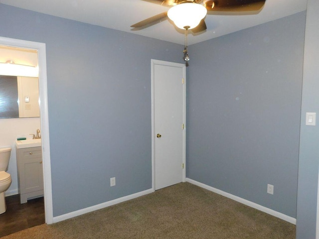 unfurnished bedroom with ceiling fan, connected bathroom, baseboards, and carpet flooring