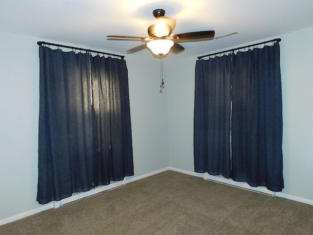 spare room featuring carpet floors, visible vents, baseboards, and a ceiling fan