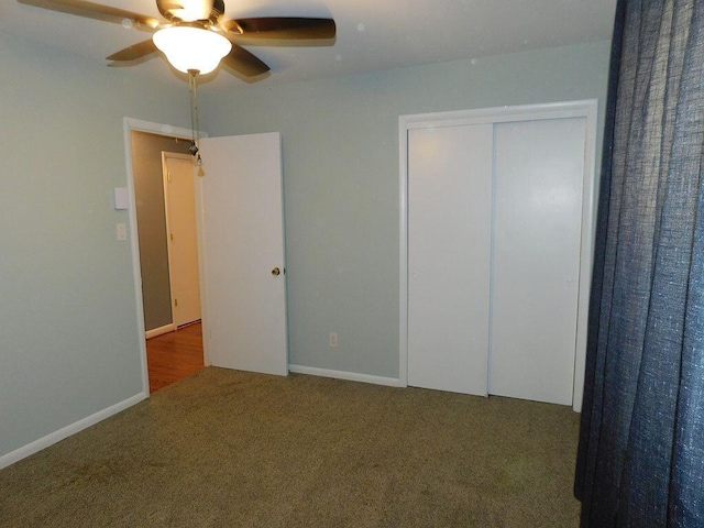 unfurnished bedroom featuring carpet, baseboards, ceiling fan, and a closet