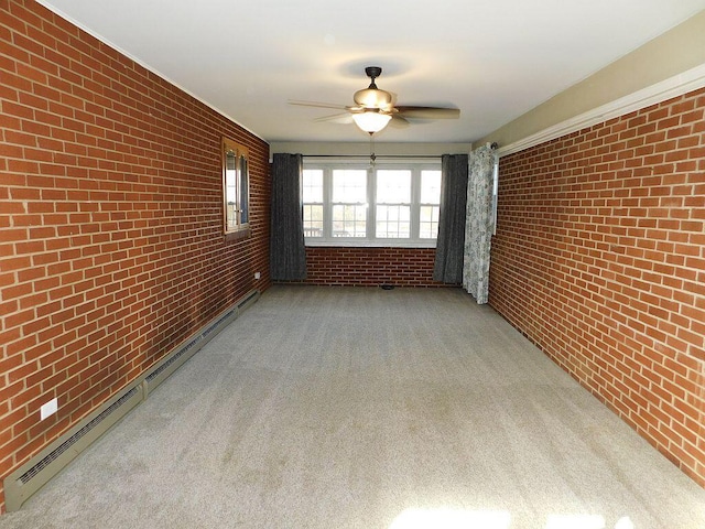 carpeted spare room featuring brick wall, a baseboard radiator, and a ceiling fan