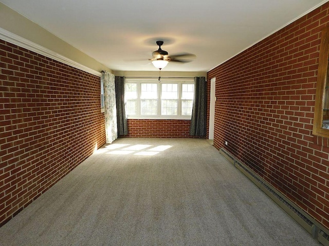 empty room featuring carpet floors, a baseboard radiator, brick wall, and a ceiling fan