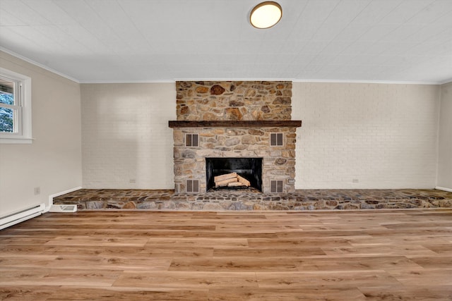 unfurnished living room with ornamental molding, a fireplace, wood finished floors, and visible vents