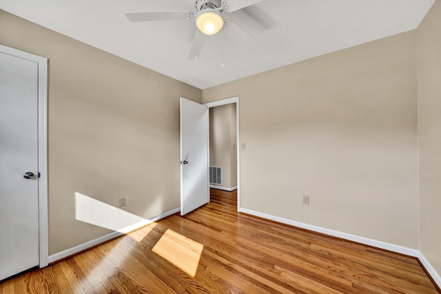 unfurnished bedroom featuring a ceiling fan, wood finished floors, visible vents, and baseboards