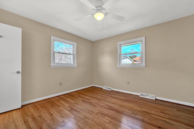 unfurnished bedroom featuring a ceiling fan, visible vents, baseboards, and wood finished floors