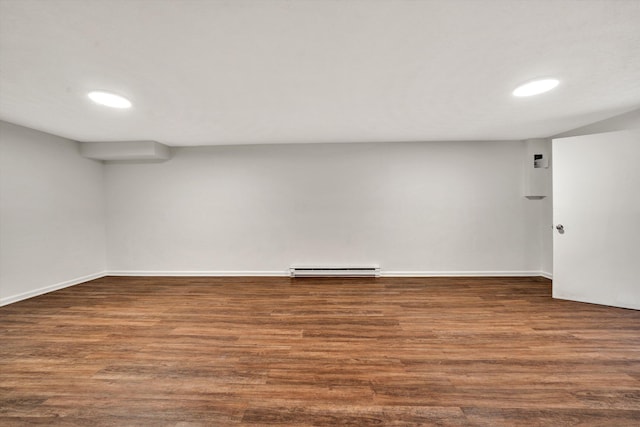 finished below grade area featuring dark wood-type flooring, a baseboard radiator, recessed lighting, and baseboards