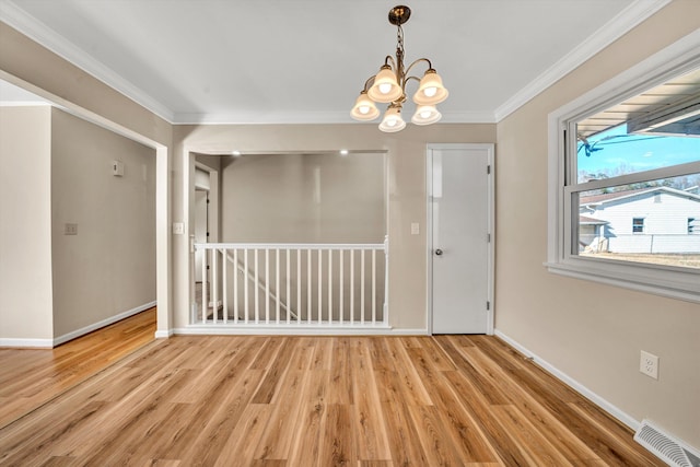 unfurnished room with light wood finished floors, ornamental molding, and visible vents