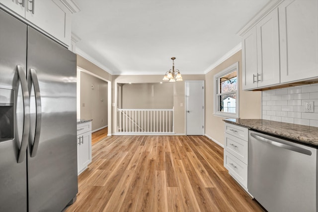 kitchen featuring crown molding, stainless steel appliances, decorative backsplash, light wood-style floors, and white cabinetry