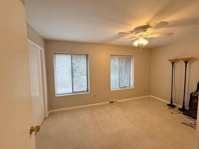 interior space featuring a ceiling fan, visible vents, and baseboards