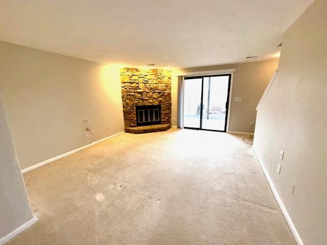 unfurnished living room featuring a fireplace, carpet flooring, and baseboards