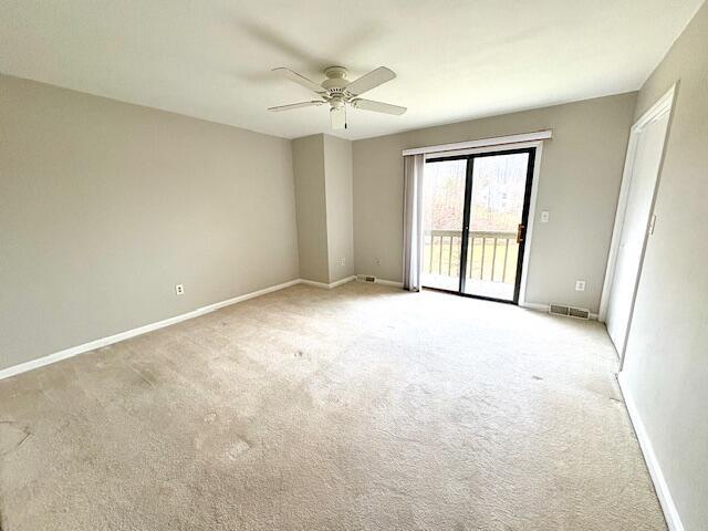 spare room with visible vents, ceiling fan, light carpet, and baseboards