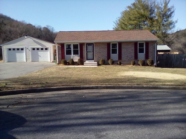 ranch-style home with fence, an outdoor structure, a front lawn, a garage, and brick siding