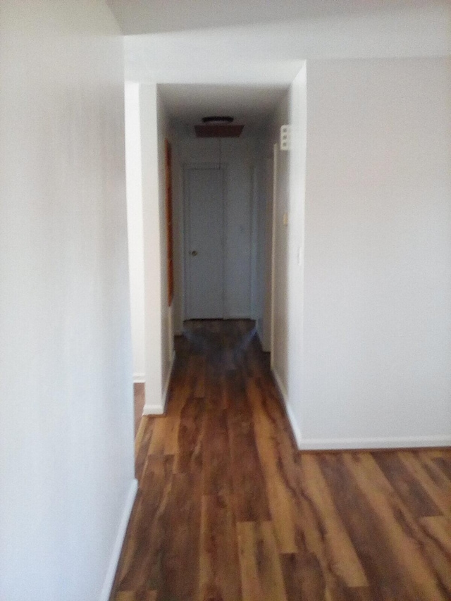 hallway with baseboards and wood finished floors